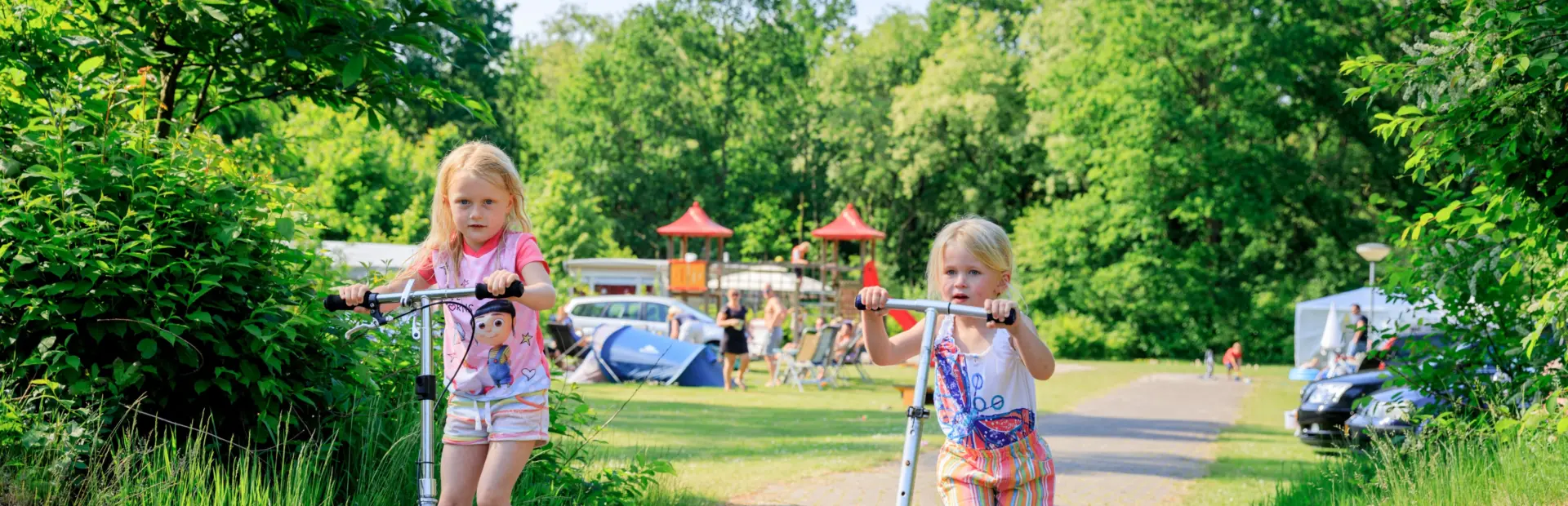 Kinderen op de step op de camping