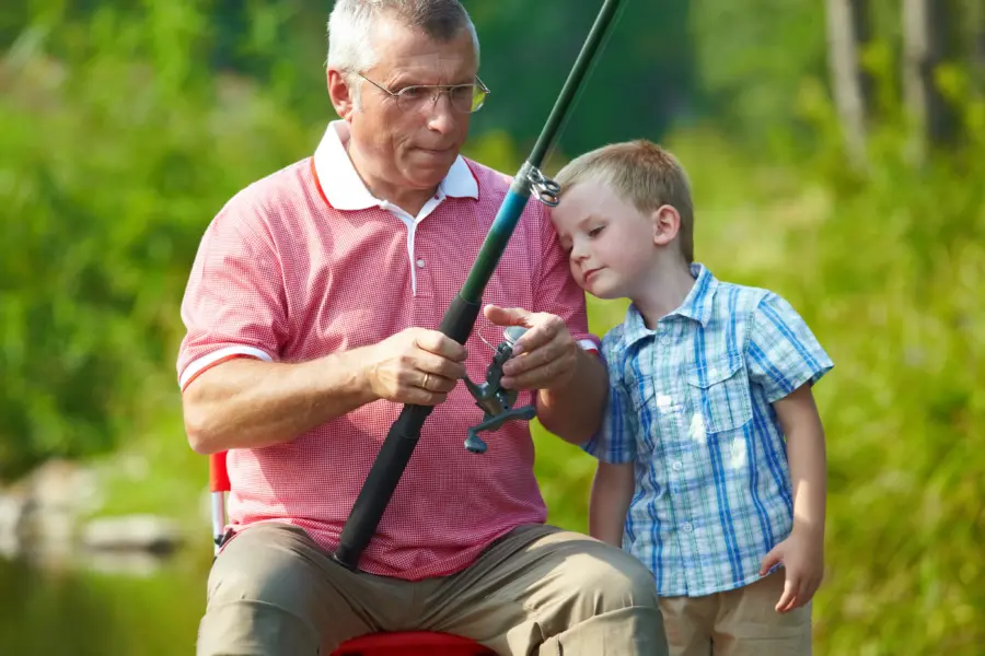 Vissen met opa en kleinkind op de camping met visvijver
