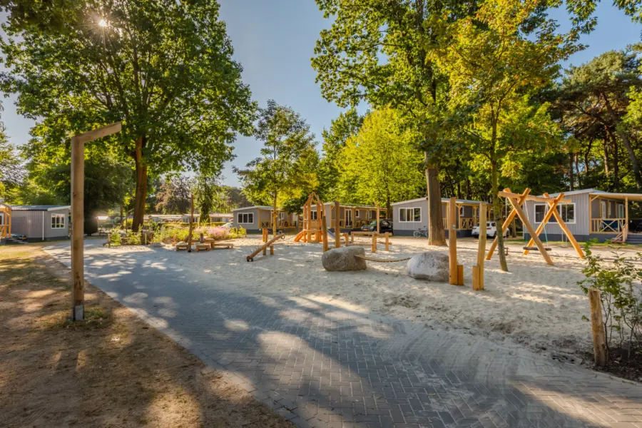 Pleintje en speeltuin bij Boschalets op Camping De Heldense Bossen
