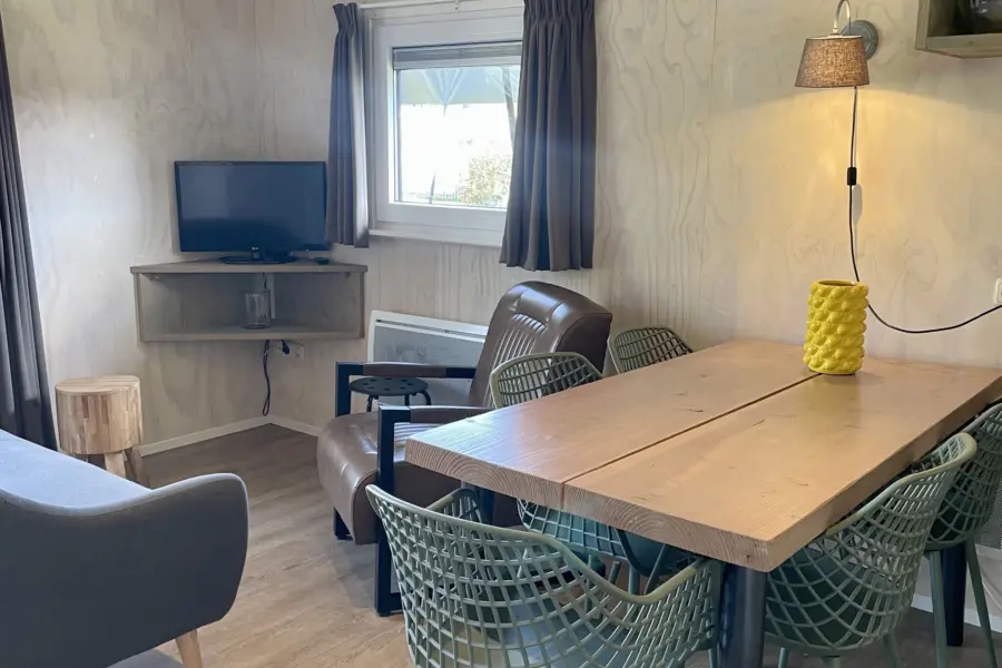 Safarilodge binnenkant tafel met stoelen en tv