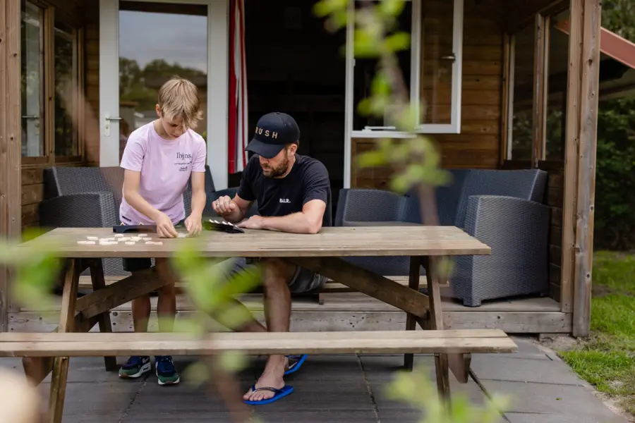 Luxe kampeerhut- vader en zoon spelen rummicub (2)