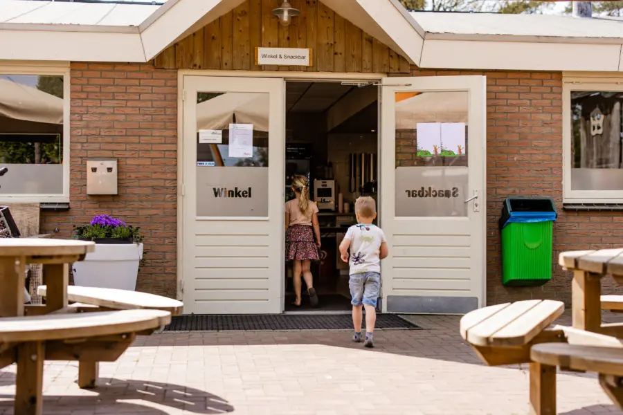Winkel kinderen lopen door de ingang