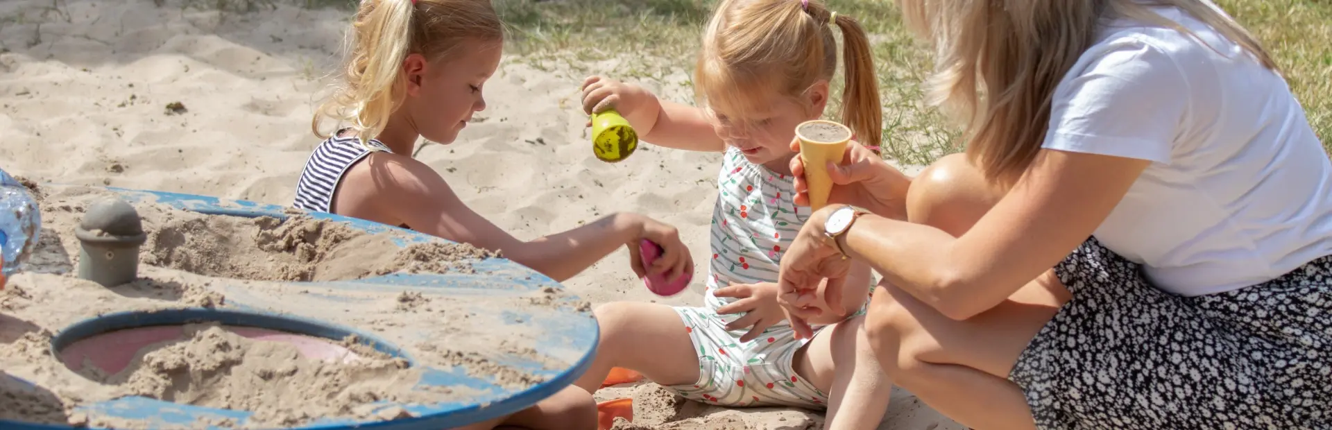 Moeder met dochter in zandbak