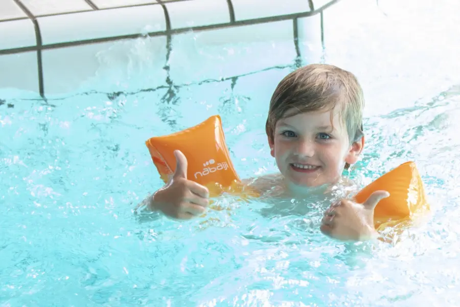 Jongetje in water met duimpjes omhoog
