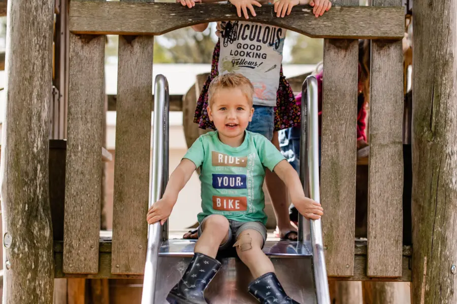 Speeltuin- kindern op de glijbaan