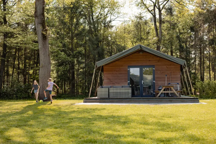 Safarilodge buitenkant met voetballende kinderen
