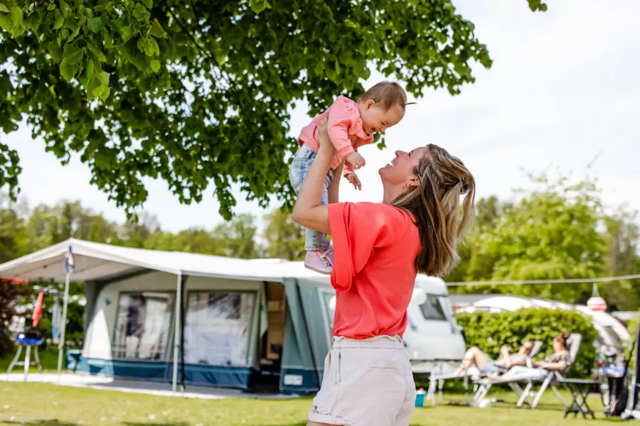Kamperen- moederspeelt met baby bij caravan 3