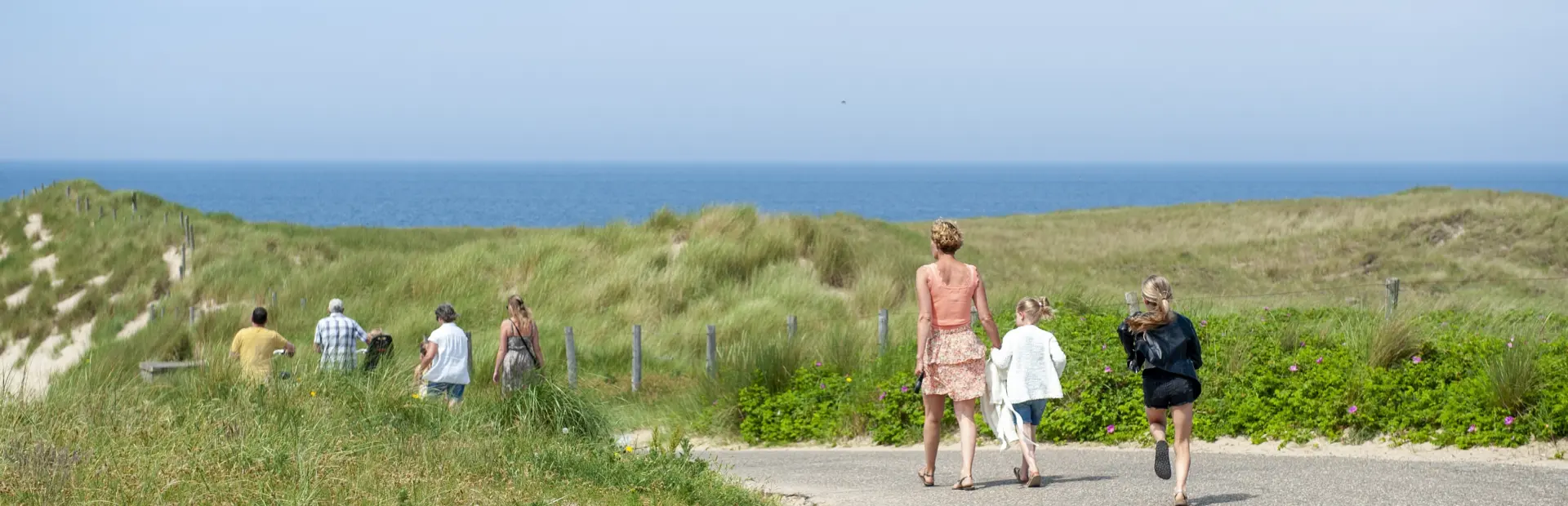 mensen in duinen met de zee