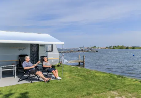 Ruime kampeerplaats met caravan bij de Paardekreek aan het Veerse Meer