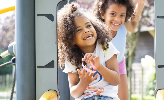 Lachende kinderen op glijbaan