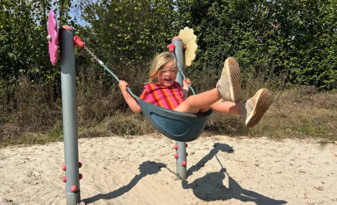 Evianne schommelen op de bloemenschommel