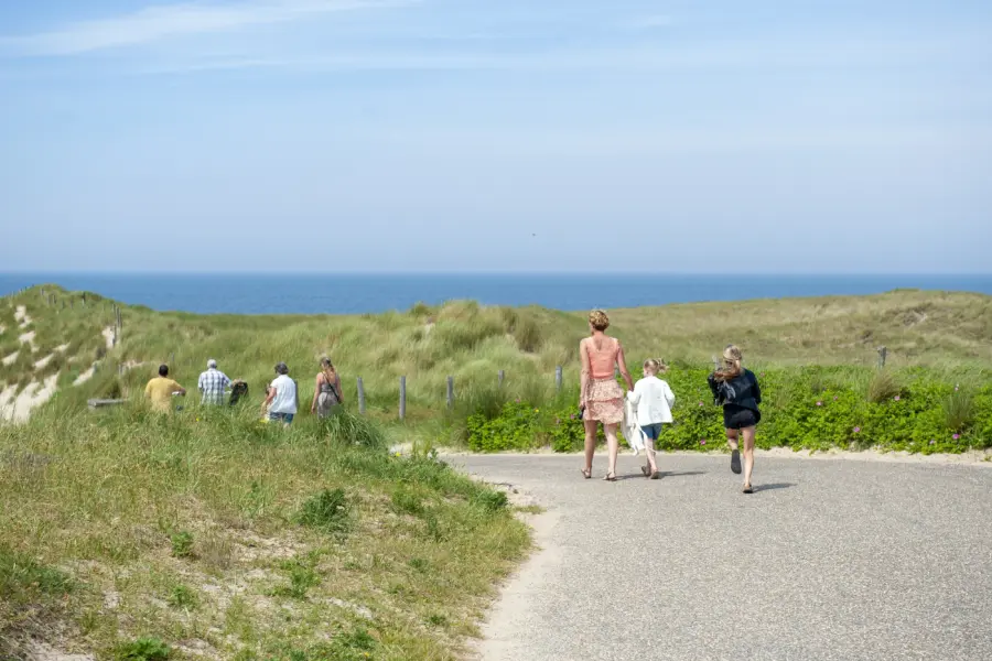 Mensen in duinen met de zee