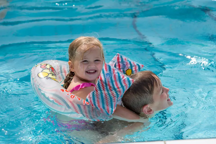 It Wiid zwembad meisje op jongetje zn rug