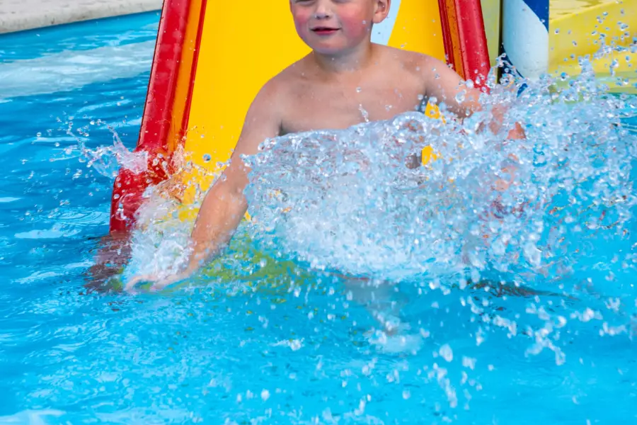 Zwembad jongen van glijbaan