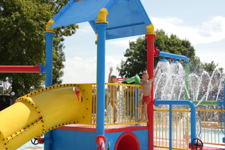 Kinderen in zwembad sproeiers