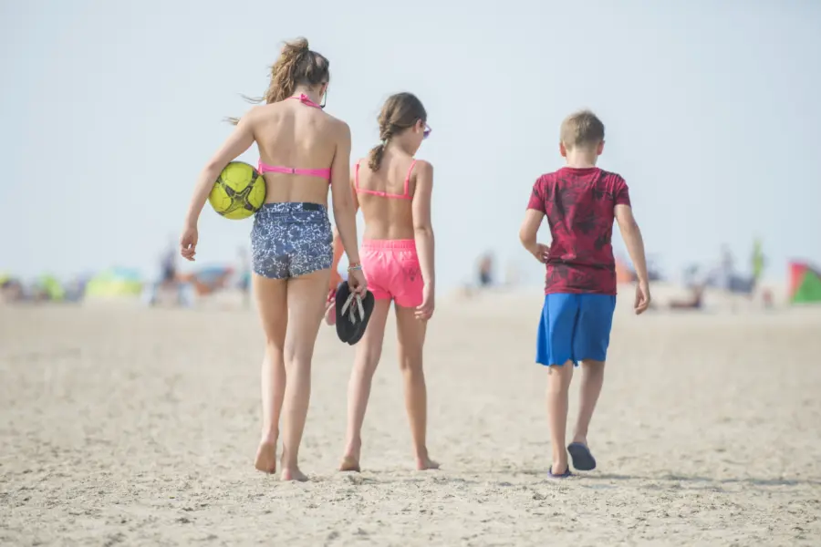 Kinderen wandelen op het strand