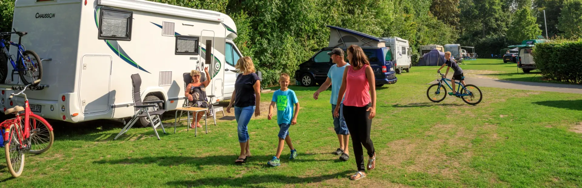 Familie loopt over kampeerplaats in de zomer op de Zwinhoeve