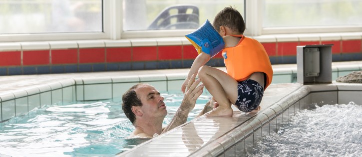 vader met zoon zwembad