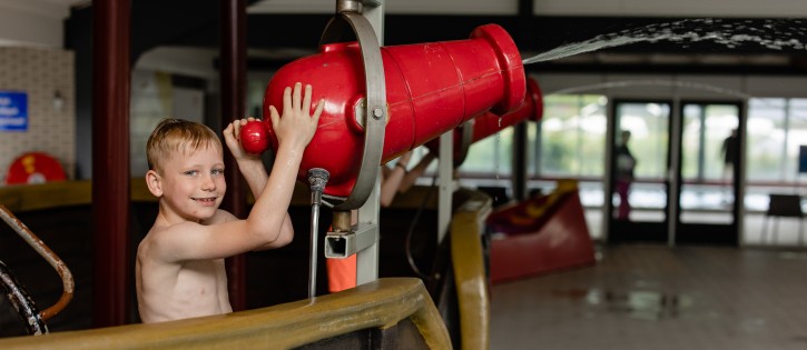 Zwembad- jongen speelt met water.jpg